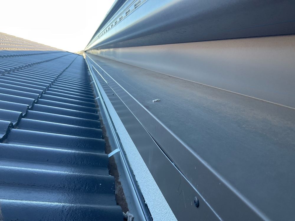 Insufficient slope on parapet capping, recorded on a pre-handover inspection in Fraser Rise